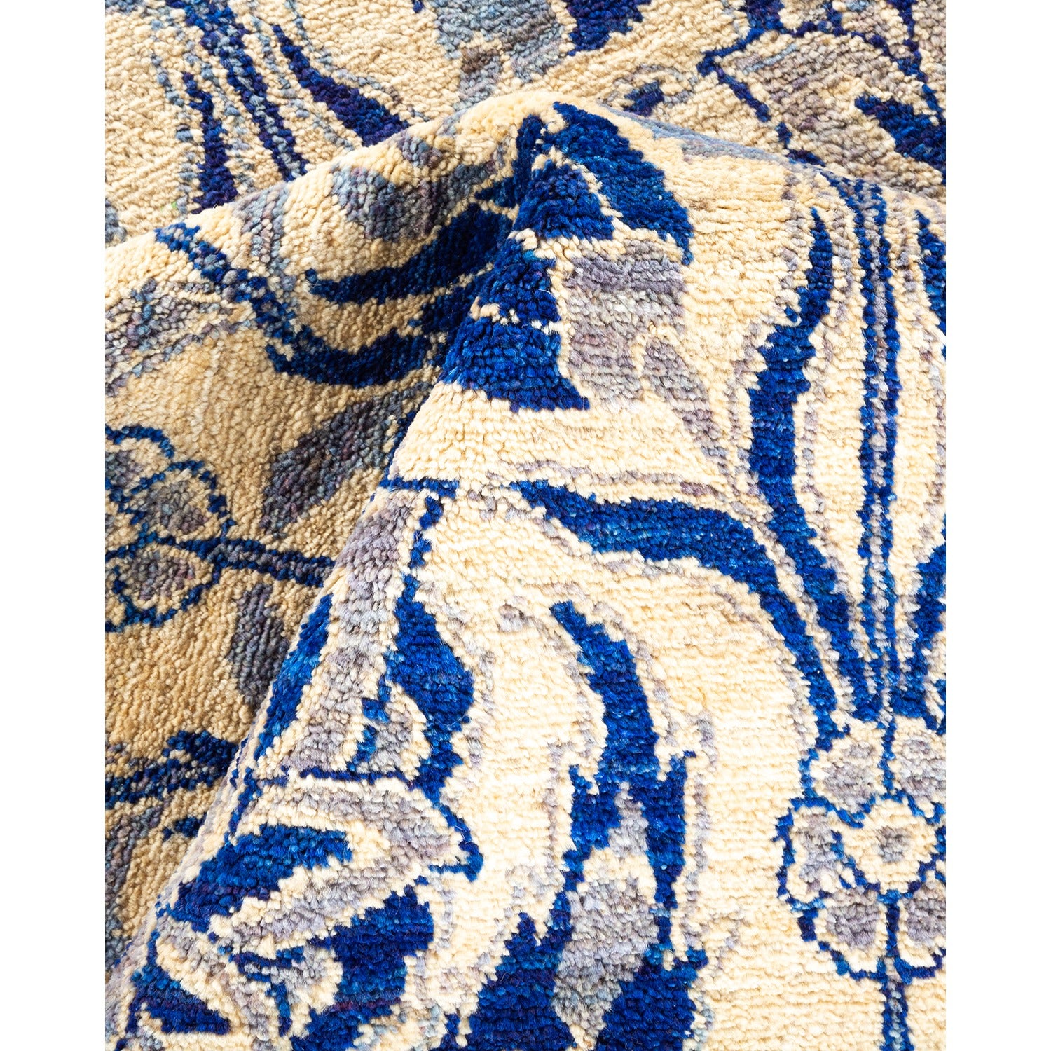 Folded patterned carpet with deep pile showcasing blue and beige.