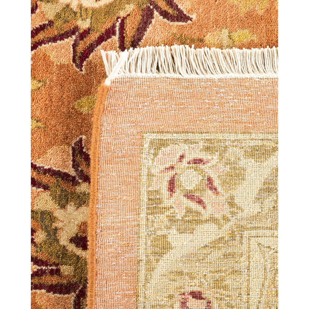 Close-up of a traditional rug with floral motifs and fringed edge.