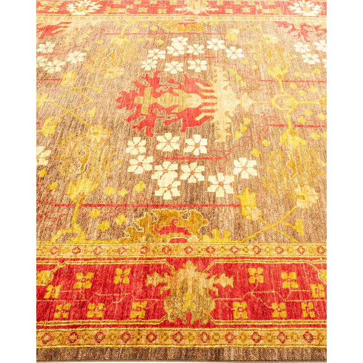 An intricately designed, vintage-style rug in warm red and gold tones.