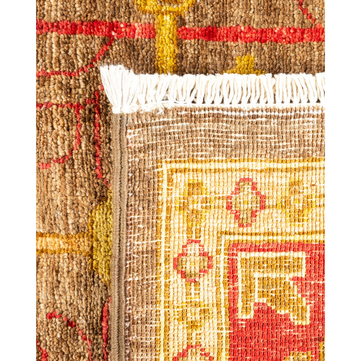 Close-up of a patterned rug with a fringed white edge.