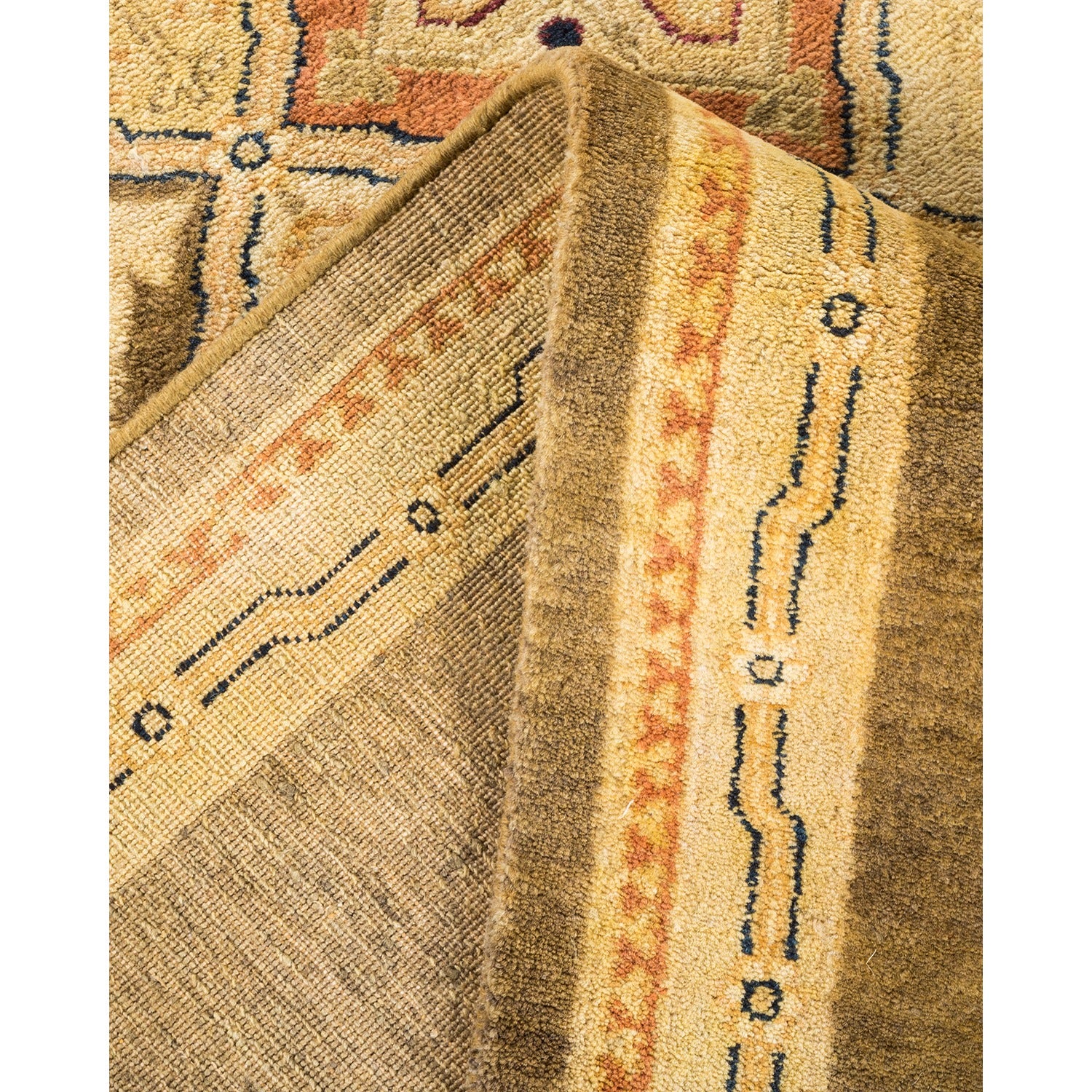 Close-up of folded textile reveals intricate traditional rug design.
