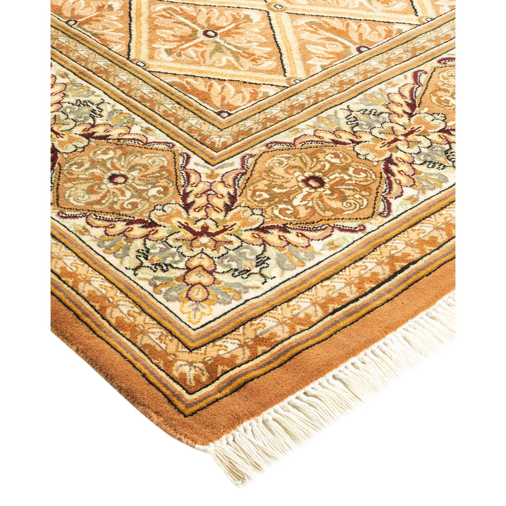Traditional ornate rug with intricate floral pattern in shades of orange, beige, and green with geometric borders and plush texture.
