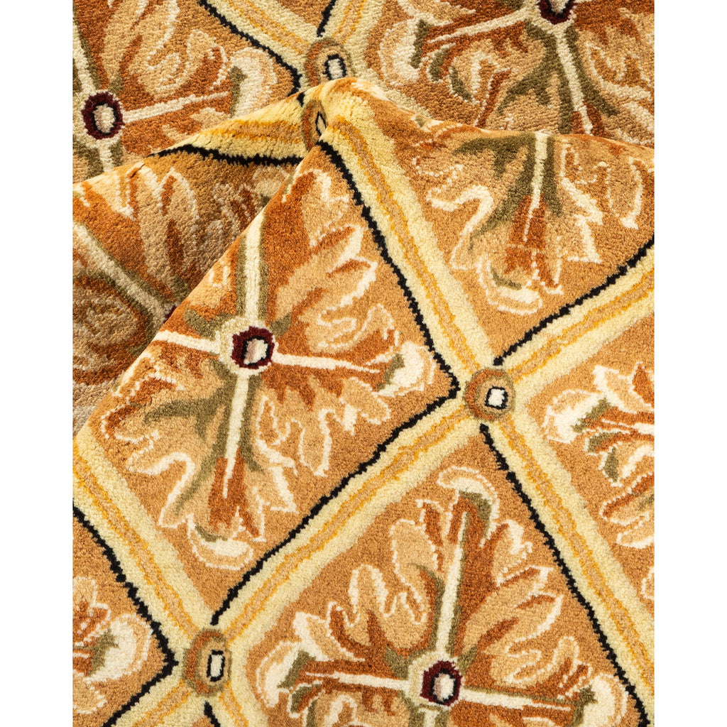 Close-up of a ornate, symmetrical patterned carpet in shades of beige, brown, and orange, with a plush, dense texture.