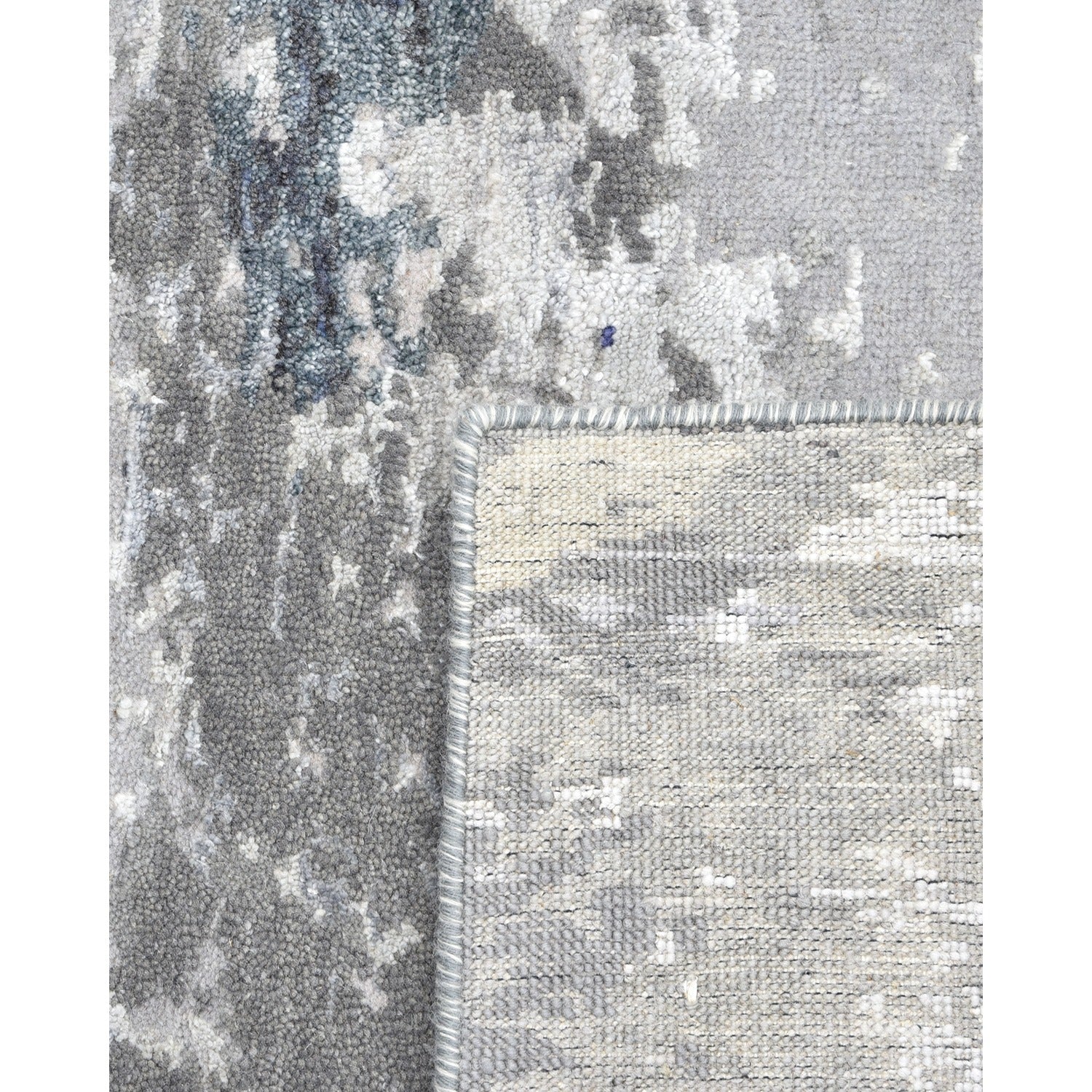 Close-up of a textured, high-quality rug with abstract blue pattern.