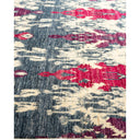 Abstract carpet with mix of dark and light colors, featuring red motifs.