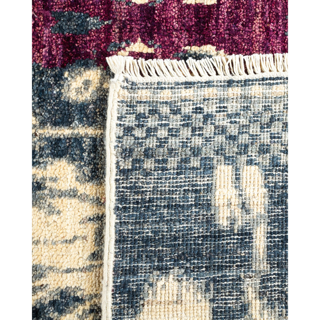 Close-up detail of rug with fringed edge, red and blue sections.
