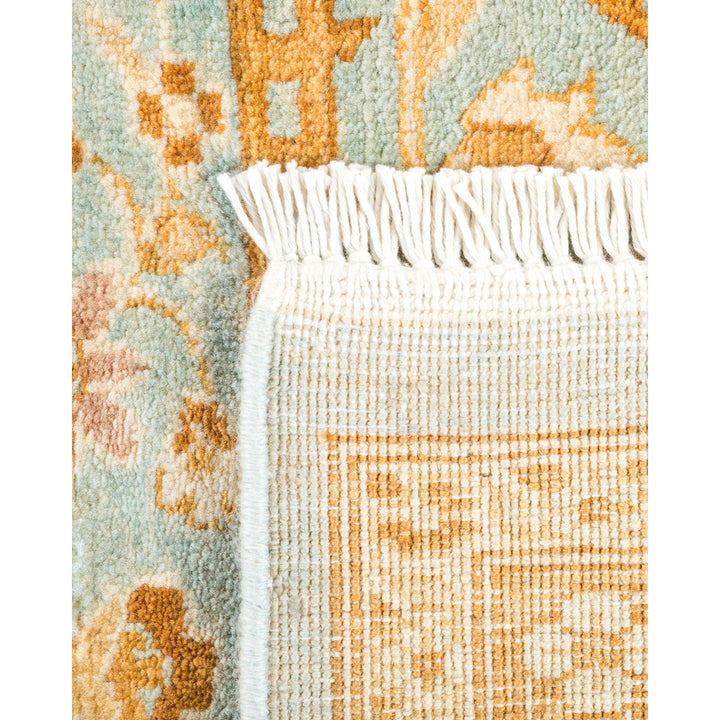 Detailed close-up of a woven rug with intricate pattern and fringe.