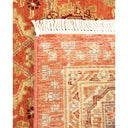Close-up of a intricately designed rug with fringe, showcasing vibrant colors and texture.