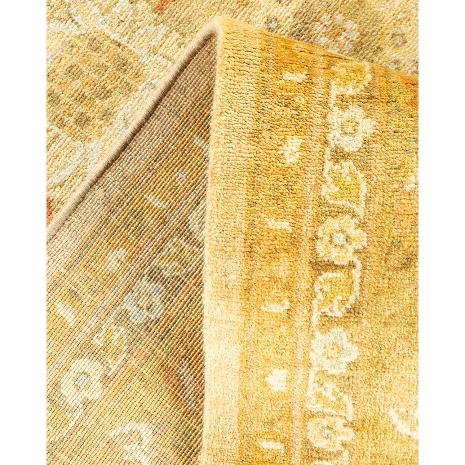 Close-up of a folded pile rug with textured underside and warm tones.