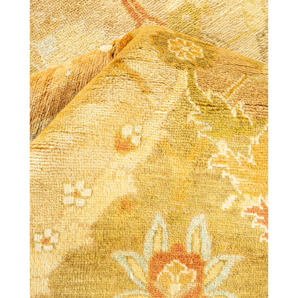 Close-up of a hand-woven rug showcasing warm, floral patterns.