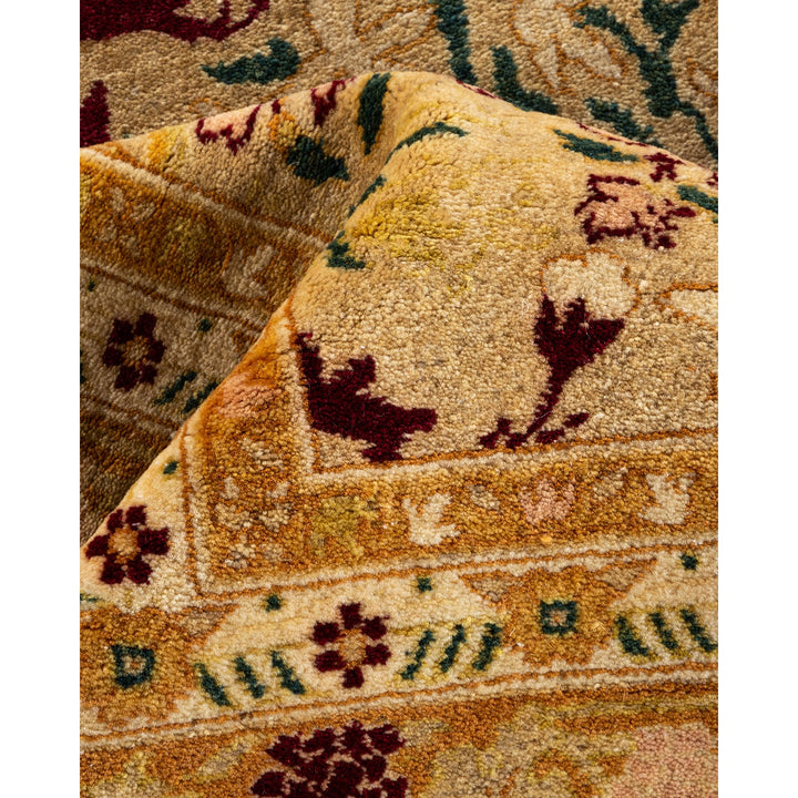 Close-up of a folded, intricately patterned rug in rich colors.