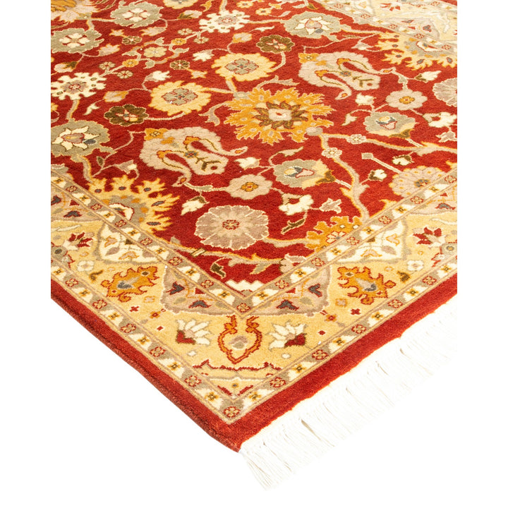 An ornate handwoven rug featuring a rich red background and floral motifs.