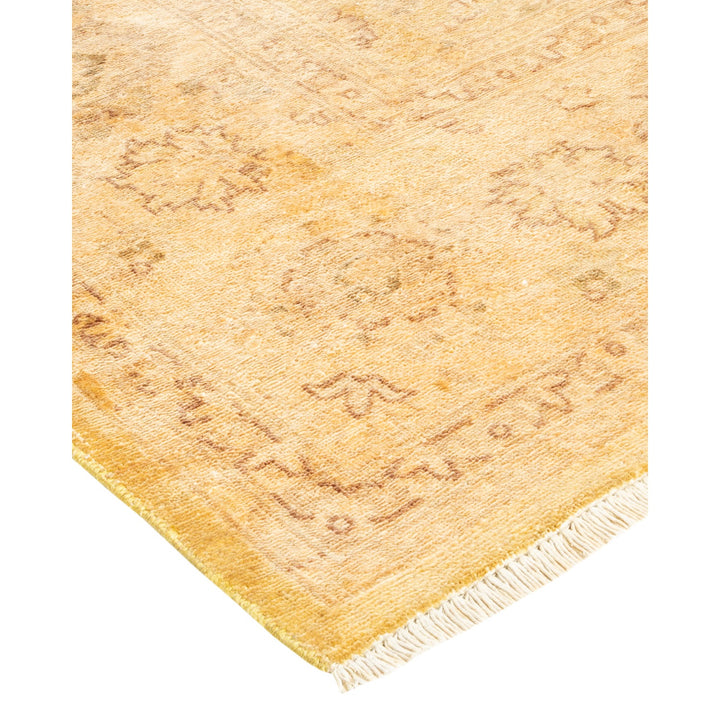 Pale golden-yellow carpet with subtle floral patterns and white fringe