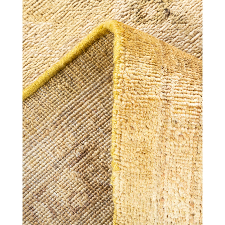 Close-up of a golden rug with plush pile and woven underside.