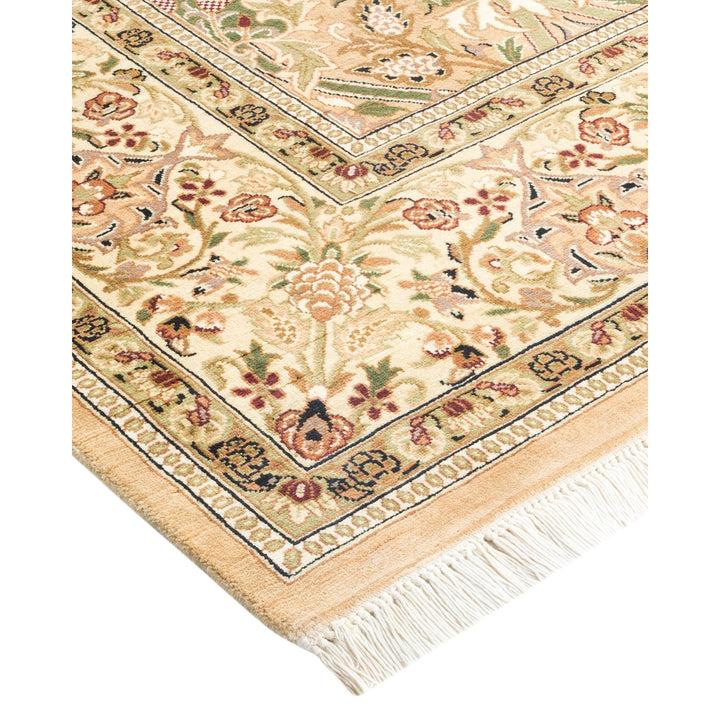 Close-up of a folded hand-woven area rug with ornate design.