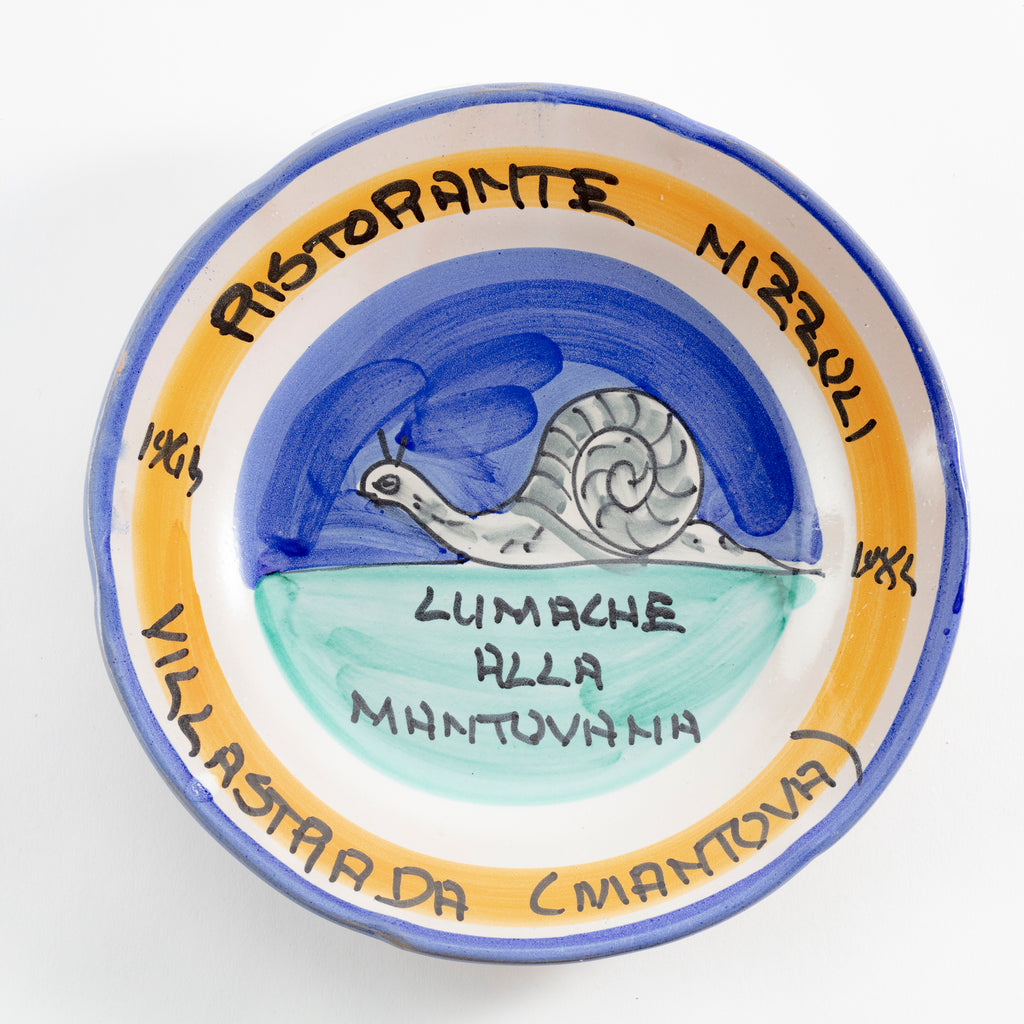 Festive ceramic plate with restaurant name, dish, and snail illustration.