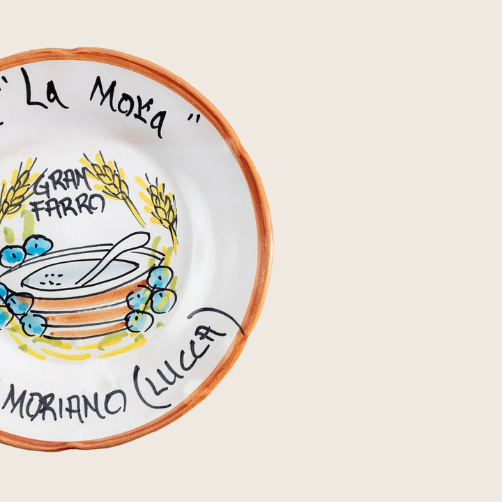 A vibrant collection of hand-painted ceramic plates with food-themed designs.