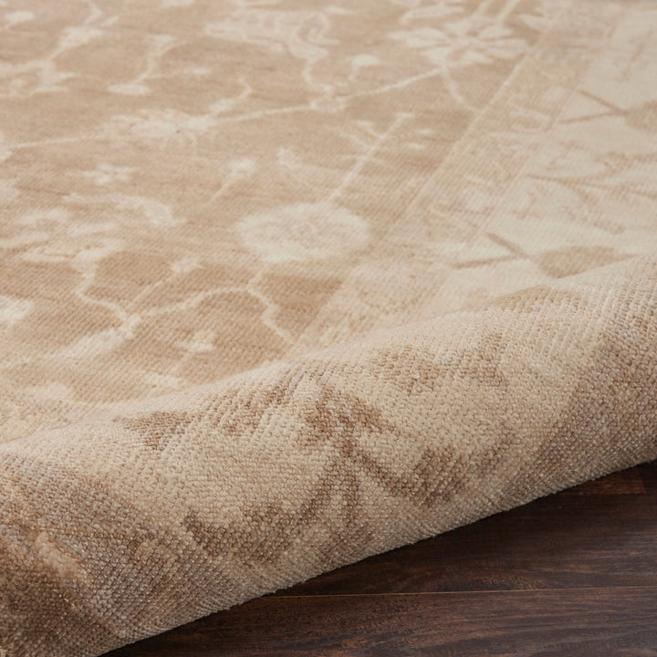 Close-up of plush, neutral area rug with subtle abstract pattern.