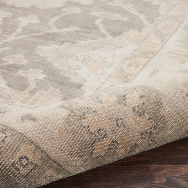 Close-up of a neutral-colored rug with traditional pattern and texture.