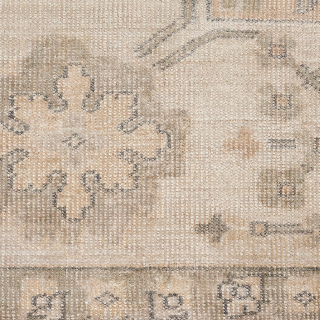Intricate, muted textile displays floral and geometric motifs in beige.
