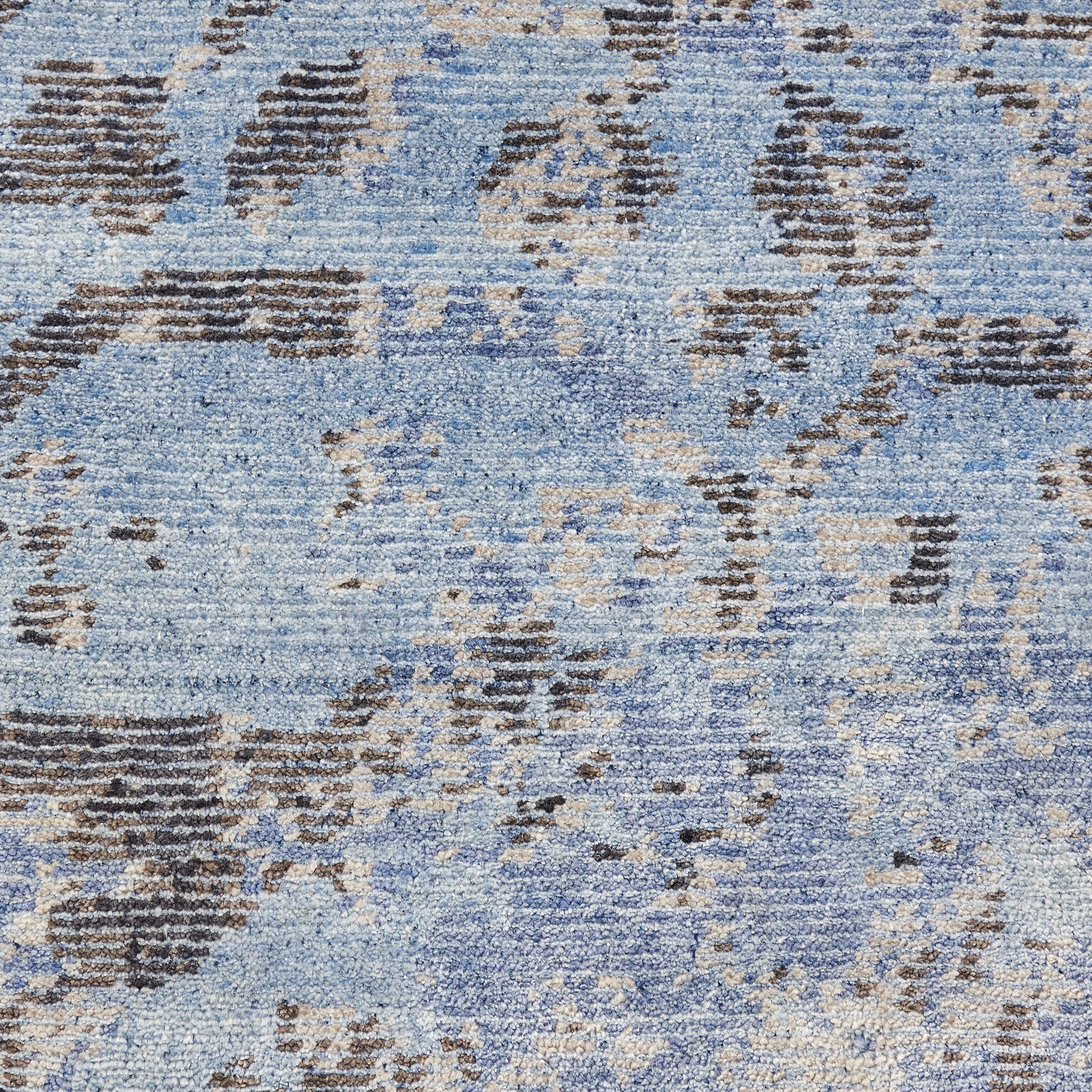 Close-up of a vintage-style blue carpet with abstract patterns.
