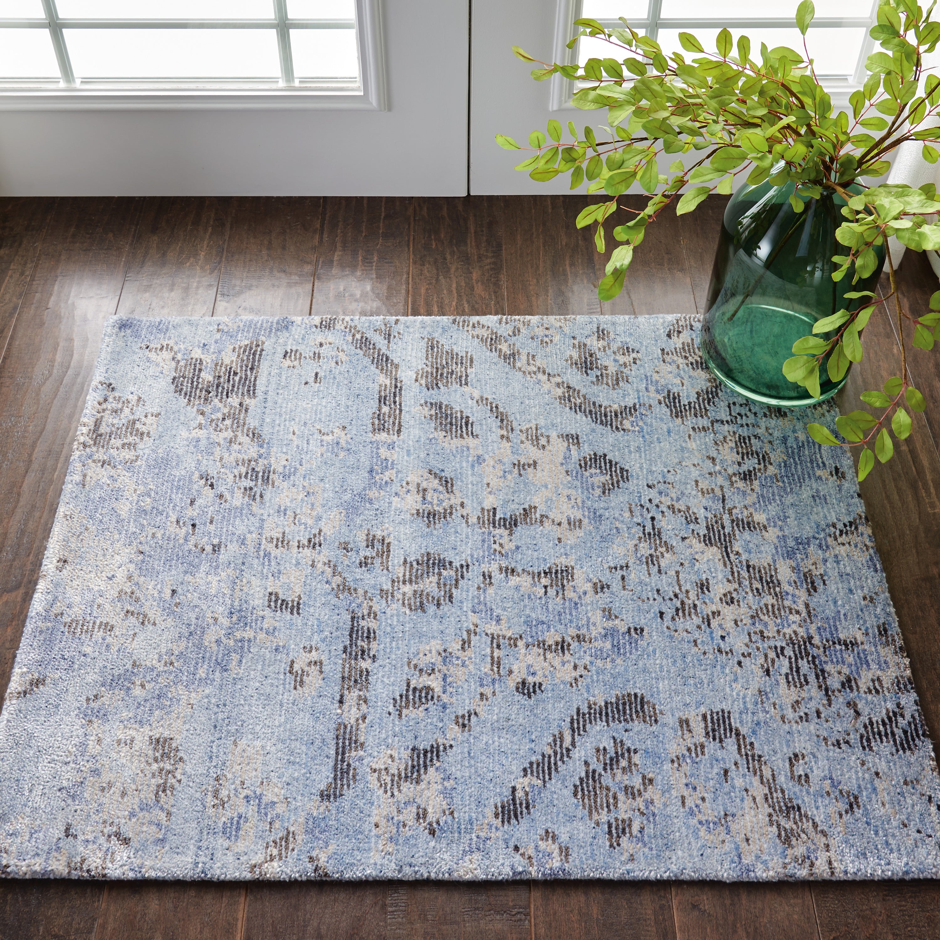 Contemporary blue patterned rug and decorative vase create cozy ambiance