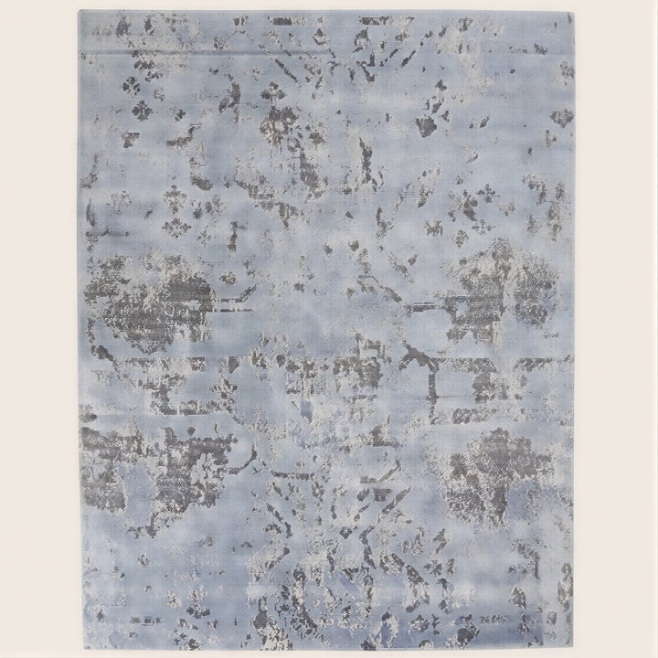 Faded blue rectangular area rug with distressed vintage pattern.