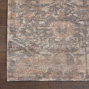 Close-up of a vintage-style, distressed area rug on wooden floor.