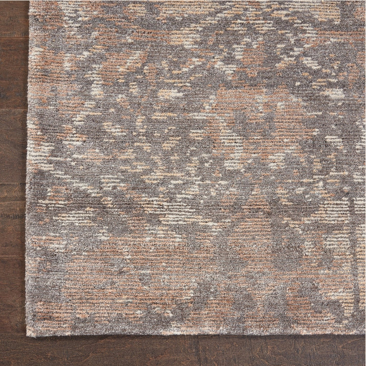 Close-up of a vintage-style, distressed area rug on wooden floor.