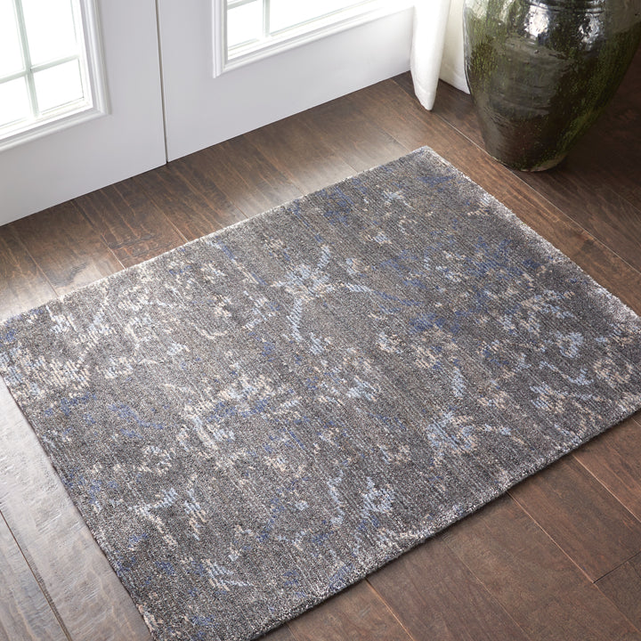 Vintage distressed area rug on wooden floor with natural lighting.