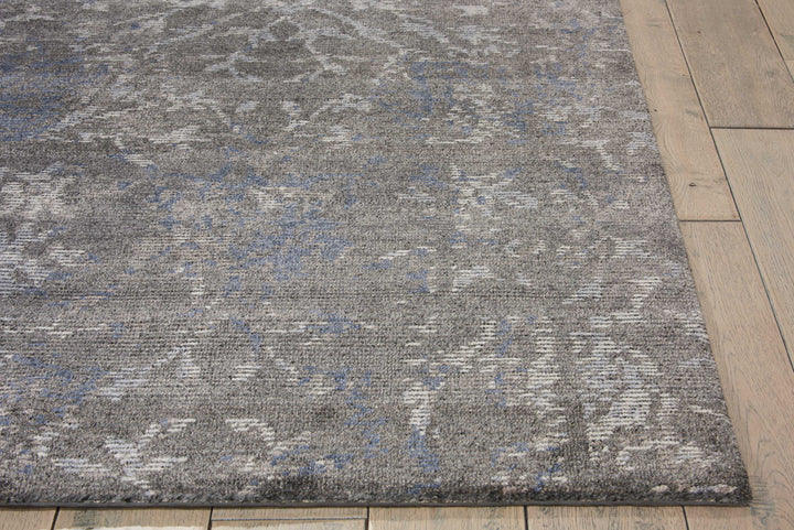 Close-up of modern, distressed gray rug with hints of blue.