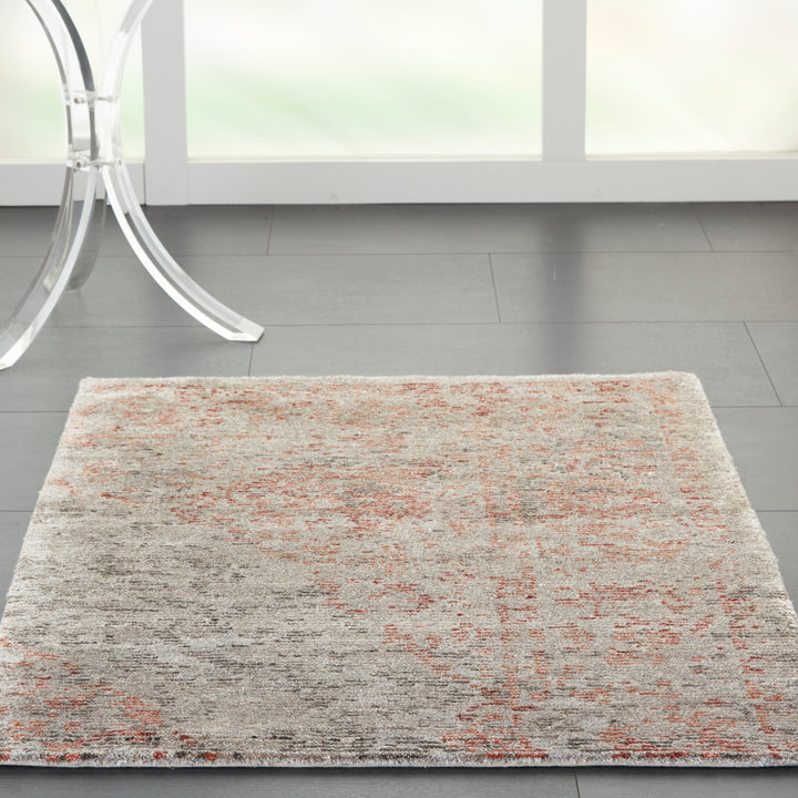 Contemporary room with abstract rug and transparent furniture legs.