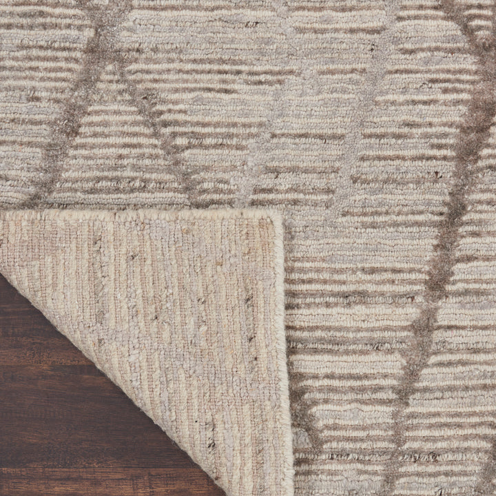 Close-up of a textured rug with striped pattern on wooden floor