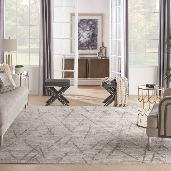 Contemporary living room with natural light, abstract rug, and modern decor.