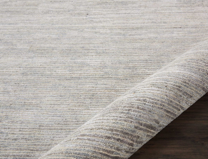 Close-up view of a textured rug on a wooden floor.