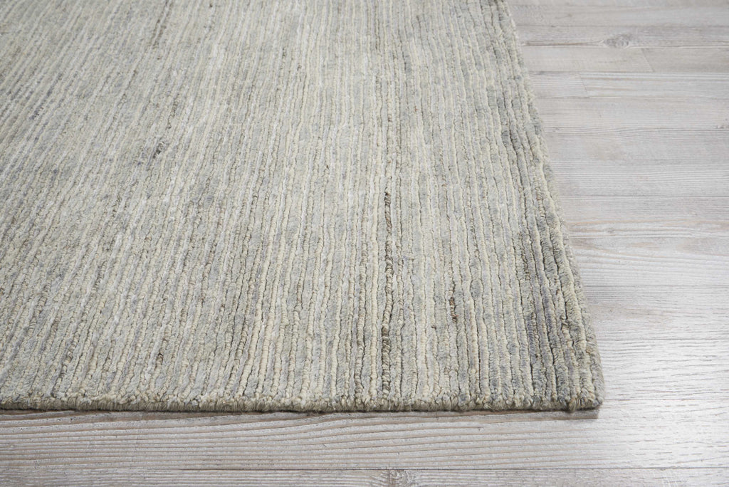 A modern, ribbed area rug on a light wooden floor.