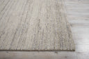 Textured area rug on wooden floor with ribbed pattern; neutral colors.