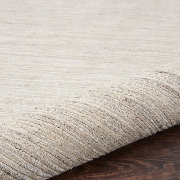 Close-up of textured rug with folded corner reveals its thickness