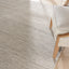 Minimalist interior design featuring textured rug and light-colored furniture.