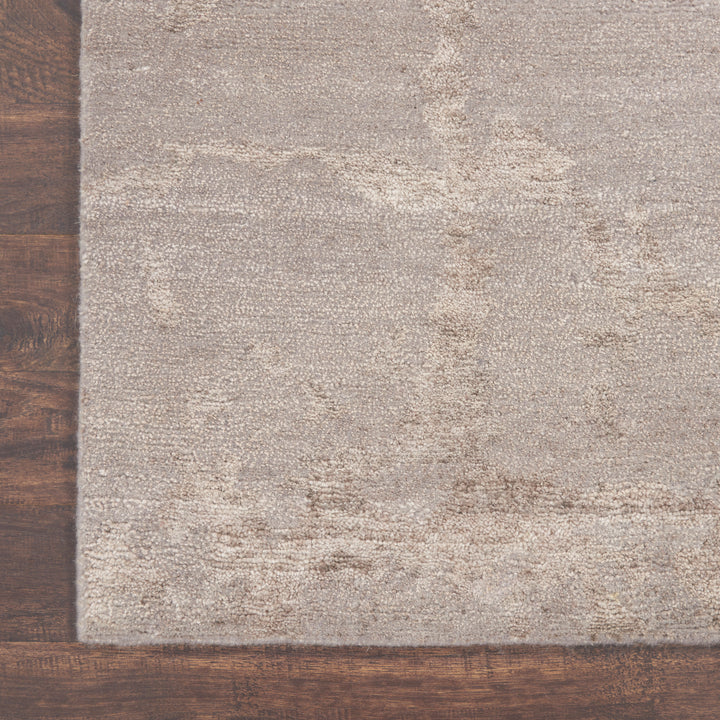 Close-up of a textured rug on a polished wooden floor.