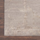 Close-up of a textured rug on a polished wooden floor.