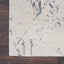 Contrasting textures: A light rug overlaps a dark wooden floor.
