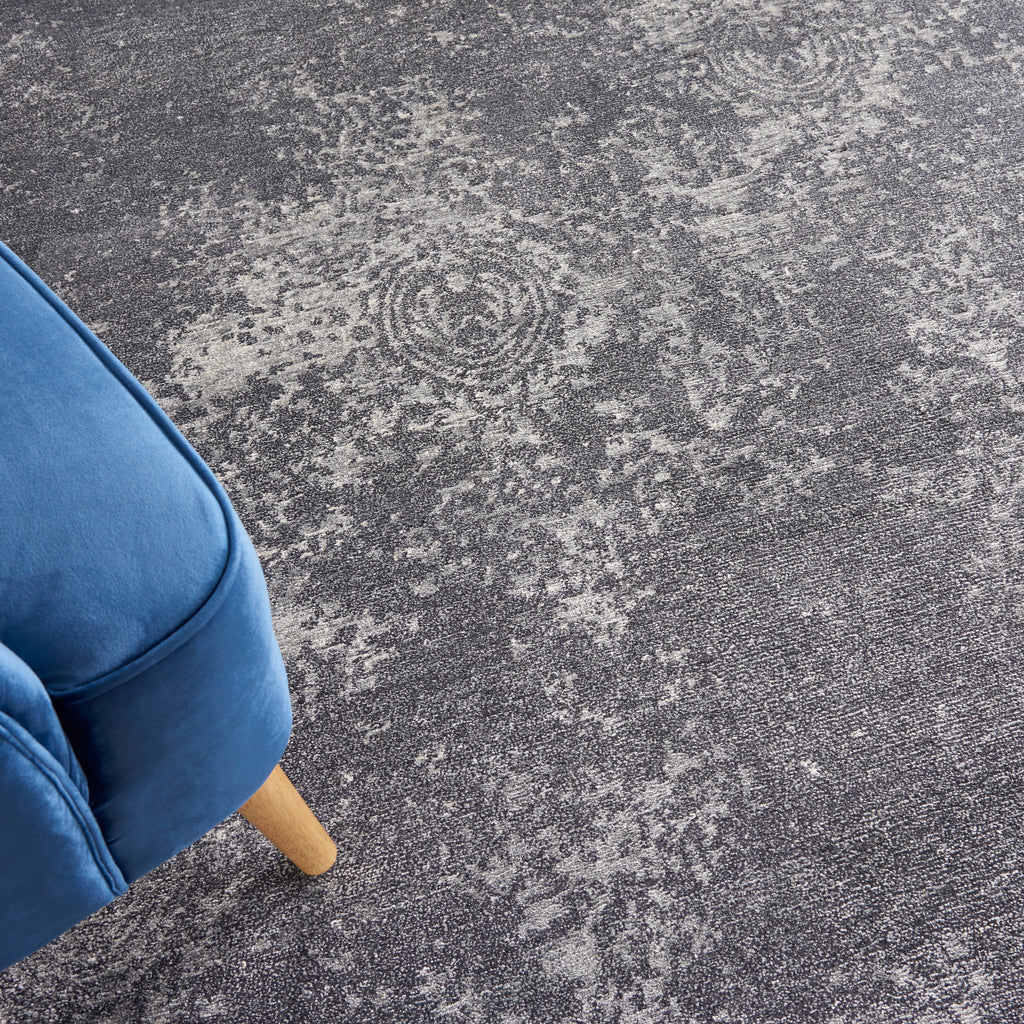 Close-up of vintage-inspired gray carpet with modern blue chair.