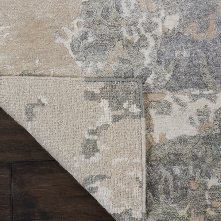 Overlapping rugs on wooden floor: one light, one darker with floral patterns.