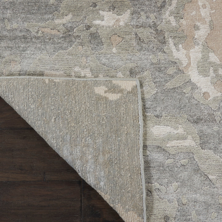Close-up view of folded rug corner reveals abstract pattern and soft texture.