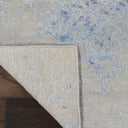 Close-up of high-quality, modern rug with abstract blue design on wooden floor.