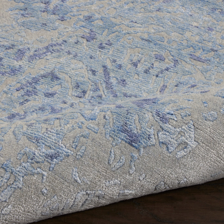 Close-up of a textured area rug with blue and grey hues.