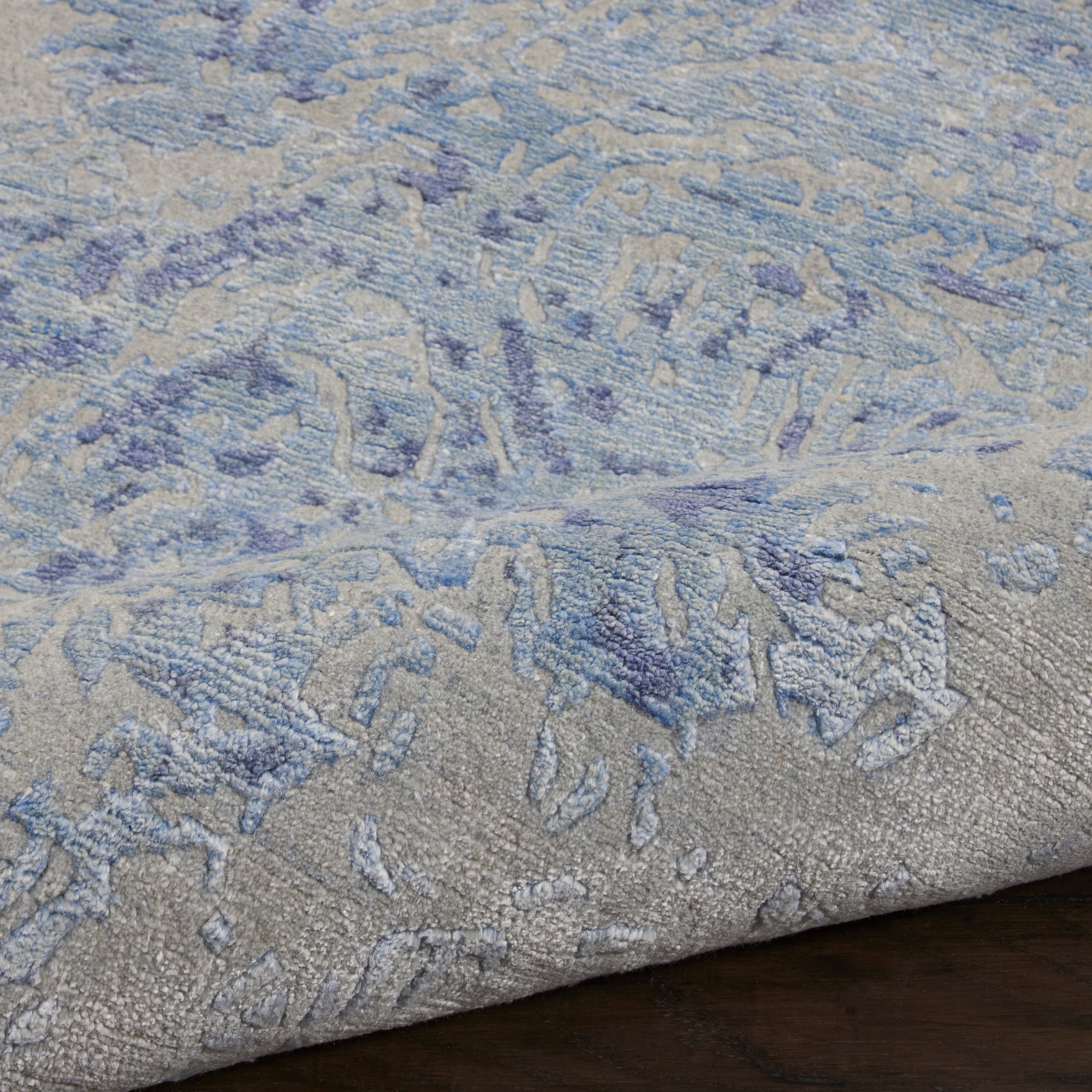 Close-up of a textured area rug with blue and grey hues.