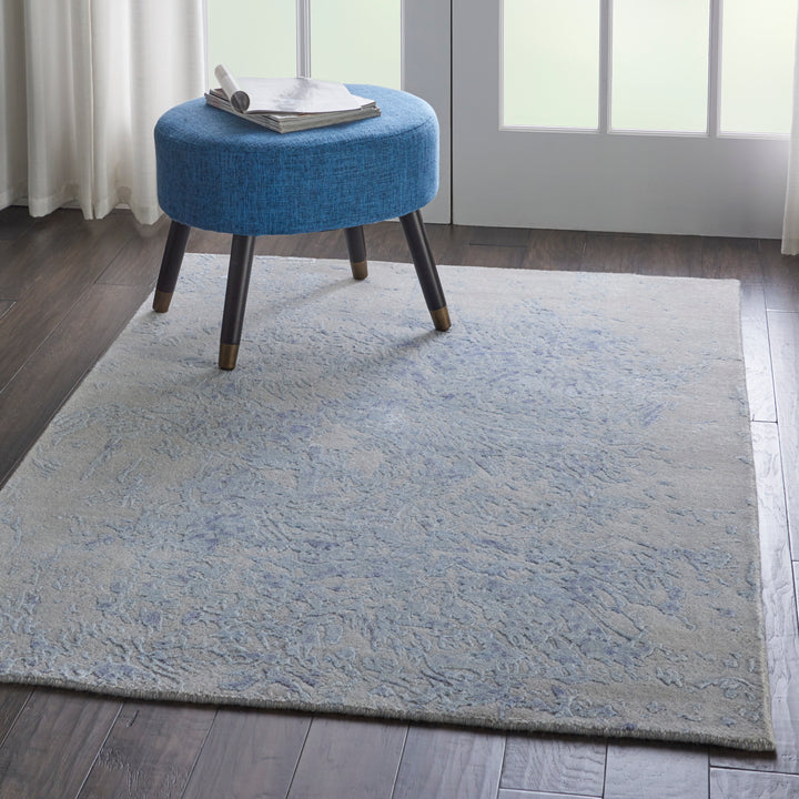 Relaxed and inviting interior featuring a blue upholstered ottoman.