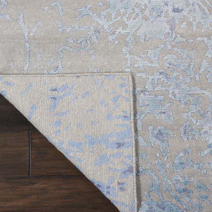 Decorative rug with intricate floral pattern contrasts against glossy hardwood.